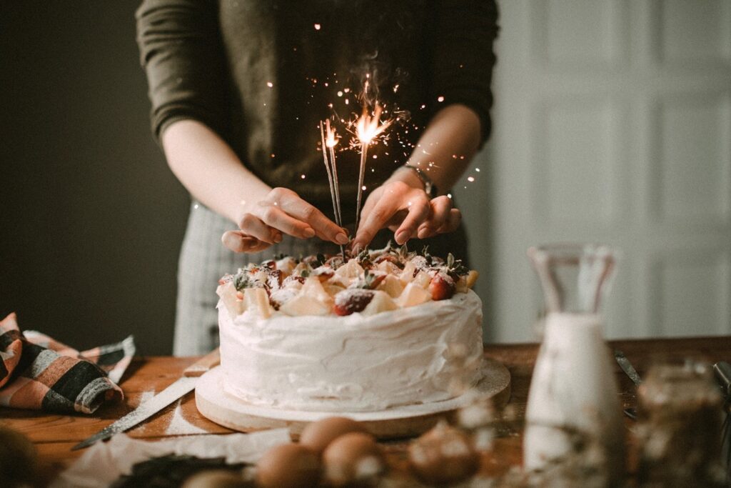 Person preparing birthday cake