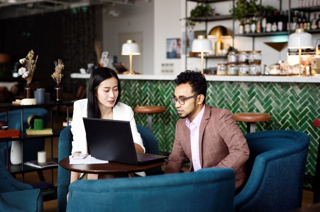 man and woman sit with laptop